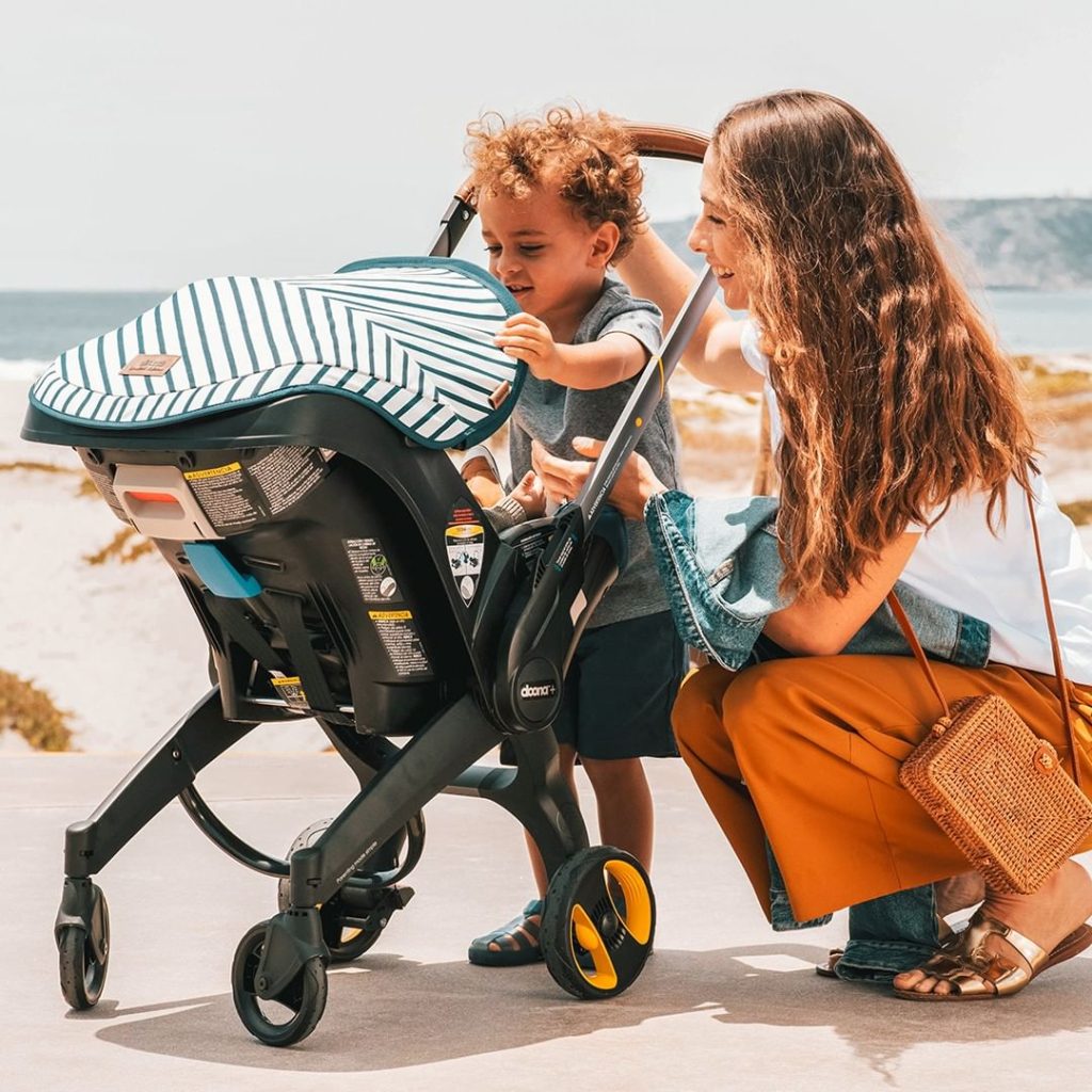 Family at the beach with their Doona stroller.